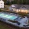 a building with a pool and a lawn with chairs and tables