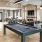 a room with a pool table and chairs